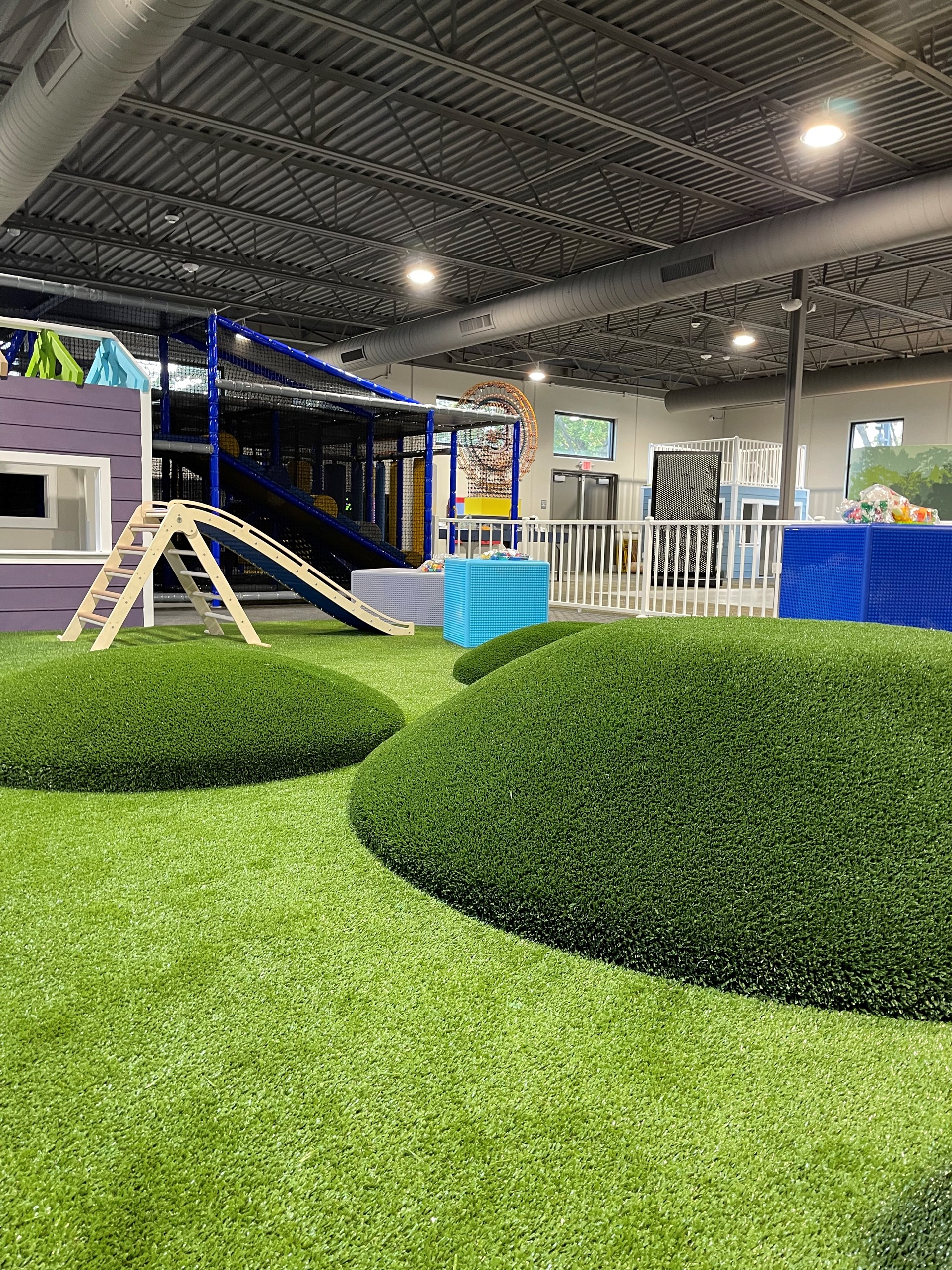 Toddler play area with soft turf and climbing mounds